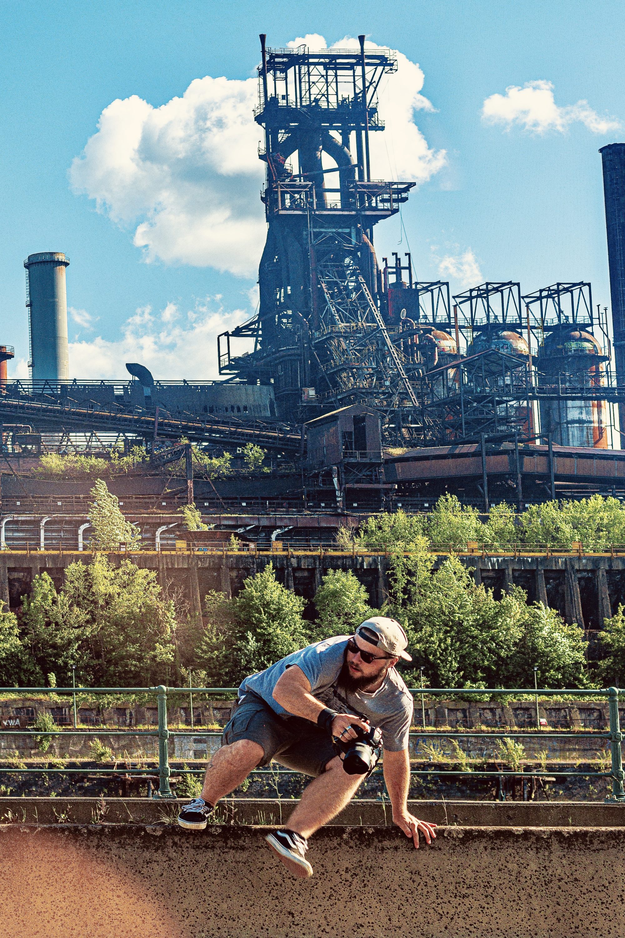 Antoine Samson, photographe du Collectif Unsettled Altitude, enjambant une berne centrale avec son appareil photo